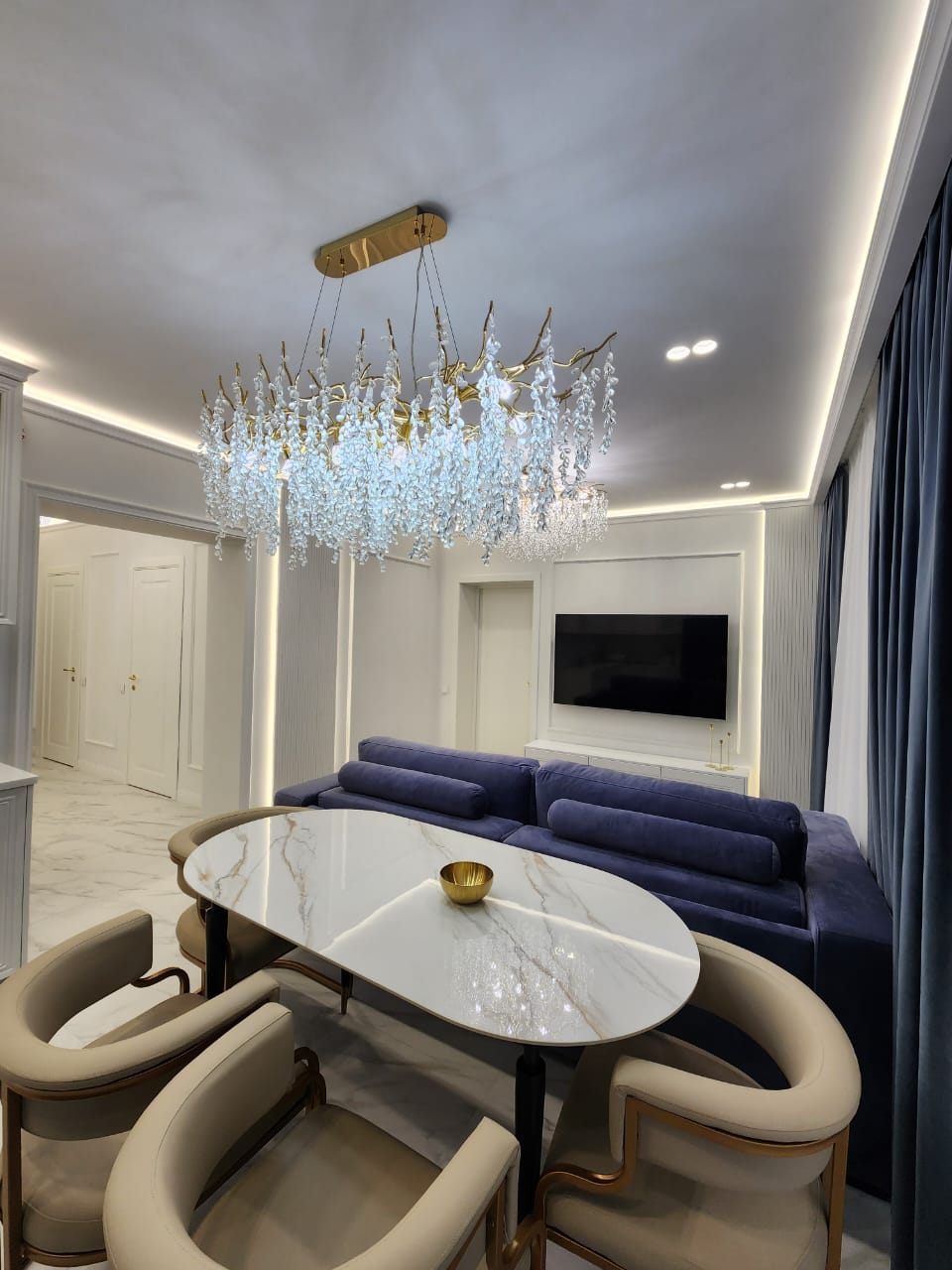 Eleganter Wohnbereich mit Kristallleuchter und Marmordetails
